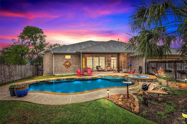 12431 Lake Vista Dr, Willis, TX 77318 - pool at dusk with a fenced backyard, a patio area, and a pool with connected hot tub
