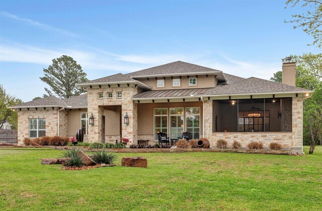 12431 Lake Vista Dr, Willis, TX 77318 - view of front facade with stone siding, a front yard, a chimney, a standing seam roof, and roof with shingles