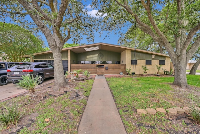 1202 Harbor View Dr, Galveston, TX 77550 - mid-century inspired home with brick siding, board and batten siding, an attached garage, and a front yard