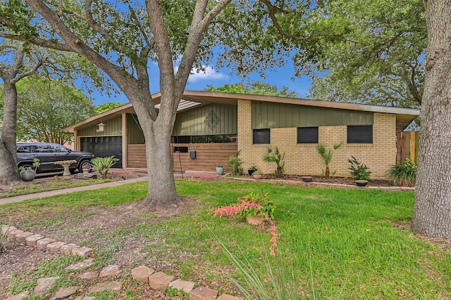 1202 Harbor View Dr, Galveston, TX 77550 - mid-century modern home with a garage, brick siding, a front yard, and board and batten siding