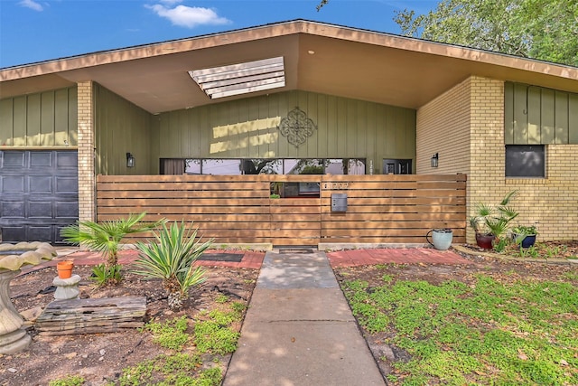 1202 Harbor View Dr, Galveston, TX 77550 - view of exterior entry with brick siding and a garage