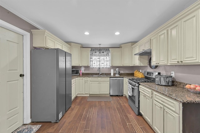 1202 Harbor View Dr, Galveston, TX 77550 - kitchen with appliances with stainless steel finishes, cream cabinetry, a sink, dark wood-type flooring, and under cabinet range hood
