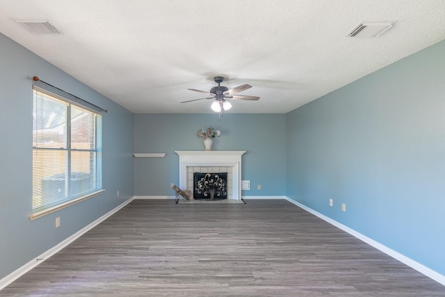 10030 Storm Meadow Dr, Houston, TX 77064 - unfurnished living room with ceiling fan, wood finished floors, a textured ceiling, a tiled fireplace, and baseboards