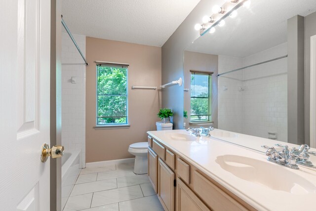 10030 Storm Meadow Dr, Houston, TX 77064 - bathroom featuring healthy amount of natural light, toilet, double vanity, washtub / shower combination, and a textured ceiling