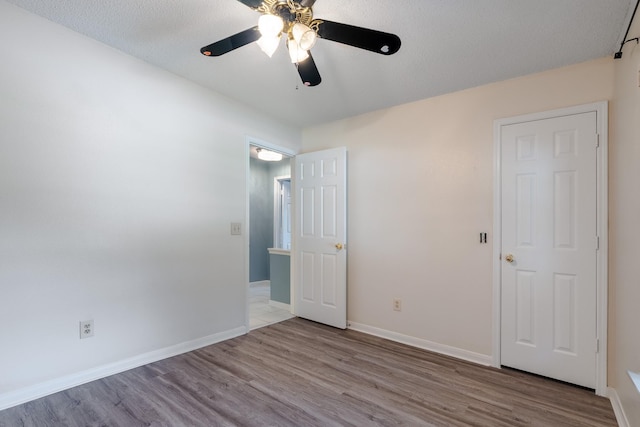 10030 Storm Meadow Dr, Houston, TX 77064 - unfurnished bedroom featuring wood finished floors, baseboards, and a ceiling fan