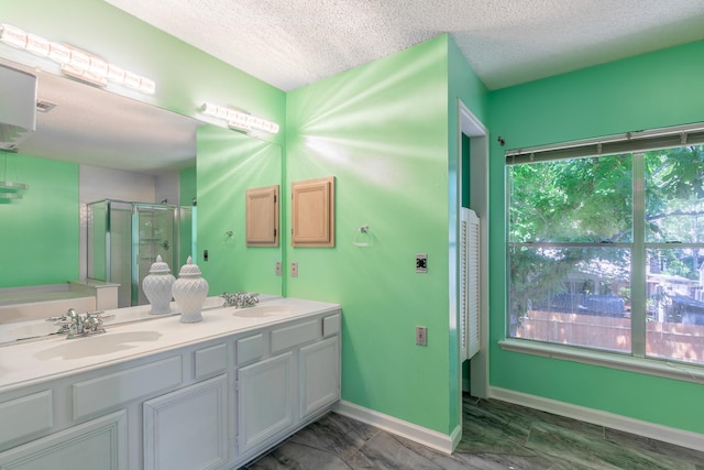 10030 Storm Meadow Dr, Houston, TX 77064 - full bathroom featuring a stall shower, a textured ceiling, double vanity, and baseboards