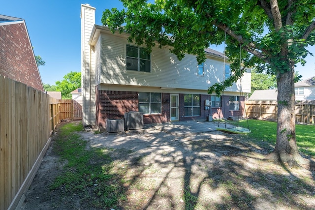 10030 Storm Meadow Dr, Houston, TX 77064 - back of property with a chimney, brick siding, a fenced backyard, and cooling unit