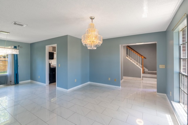 10030 Storm Meadow Dr, Houston, TX 77064 - spare room with a chandelier, a textured ceiling, stairs, and baseboards