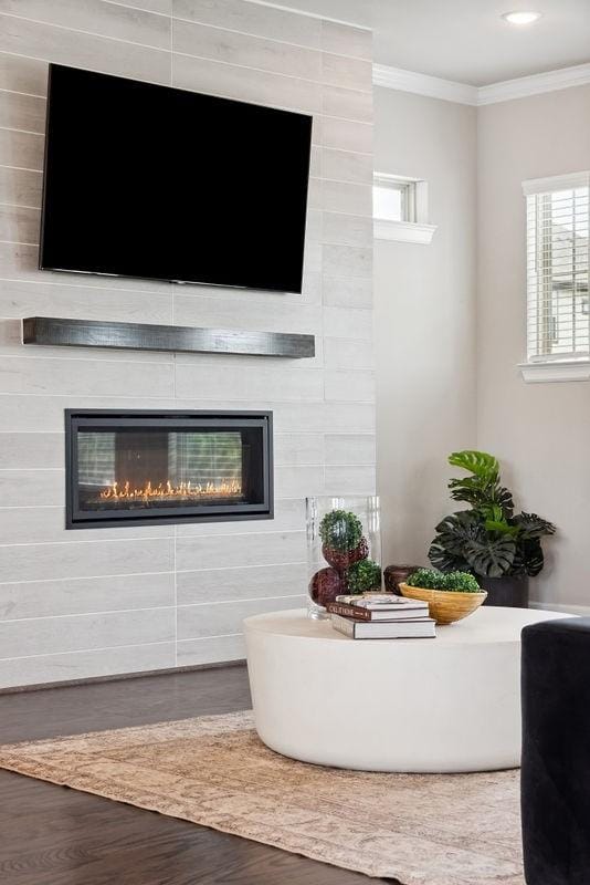 10603 Centre Green Way, Houston, TX 77043 - living area featuring a large fireplace, wood finished floors, and ornamental molding
