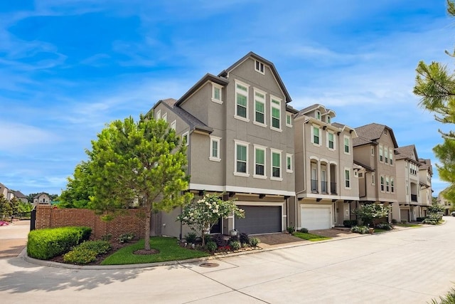10603 Centre Green Way, Houston, TX 77043 - view of property exterior with a residential view, a garage, stucco siding, and driveway