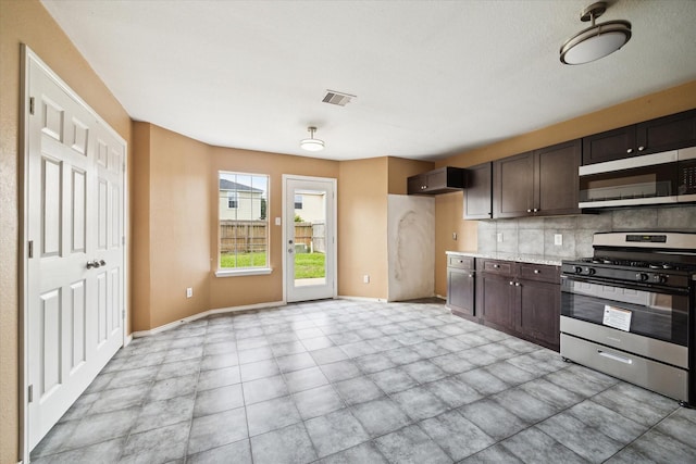 10010 Victoria Falls Ln, Houston, TX 77075 - kitchen with stainless steel appliances, dark brown cabinets, light countertops, decorative backsplash, and baseboards