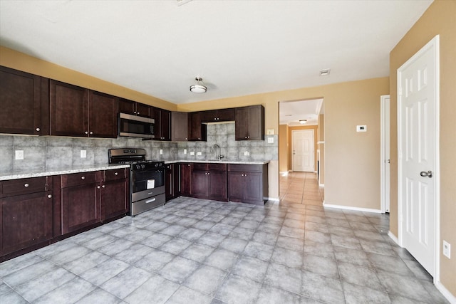 10010 Victoria Falls Ln, Houston, TX 77075 - kitchen with stainless steel appliances, backsplash, dark brown cabinetry, and baseboards