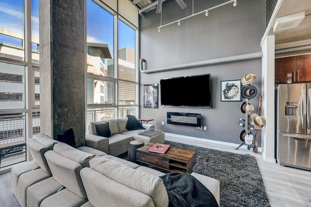 2000 Bagby St Unit 5426, Houston, TX 77002 - living area featuring a towering ceiling, light wood-style floors, healthy amount of natural light, track lighting, and baseboards