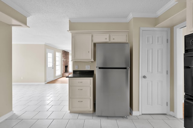 1614 Sweet Grass Trl, Houston, TX 77090 - kitchen with freestanding refrigerator, a textured ceiling, baseboards, light tile patterned floors, and ornamental molding