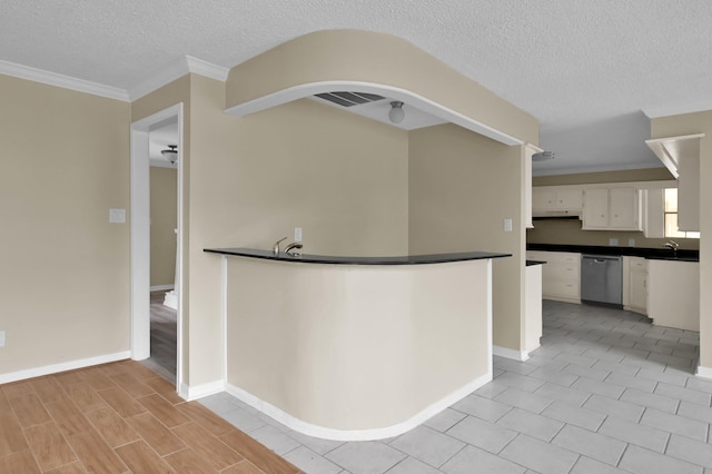 1614 Sweet Grass Trl, Houston, TX 77090 - kitchen with stainless steel dishwasher, dark countertops, white cabinetry, ornamental molding, and a textured ceiling