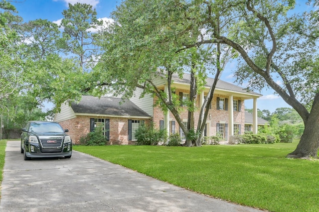 1614 Sweet Grass Trl, Houston, TX 77090 - neoclassical home with brick siding, a front yard, a shingled roof, and driveway