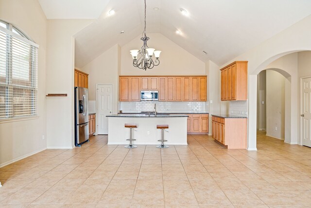 28523 Kinglet Pines Dr, Katy, TX 77494 - kitchen featuring stainless steel appliances, high vaulted ceiling, arched walkways, a chandelier, and tasteful backsplash