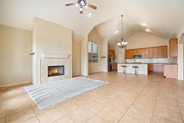 28523 Kinglet Pines Dr, Katy, TX 77494 - unfurnished living room featuring high vaulted ceiling, a chandelier, a ceiling fan, light tile patterned floors, and a fireplace