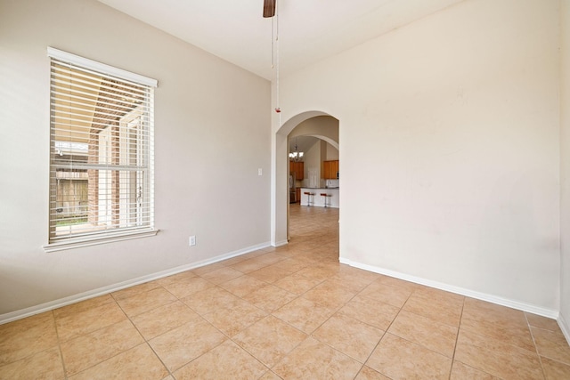 28523 Kinglet Pines Dr, Katy, TX 77494 - empty room with arched walkways, light tile patterned floors, and baseboards