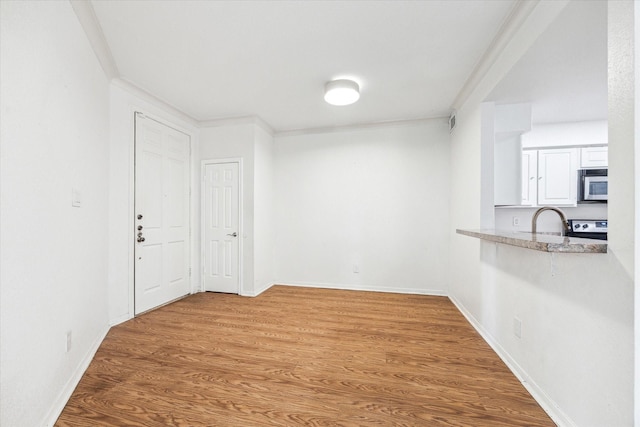 5210 Weslayan St Unit 112, Houston, TX 77005 - unfurnished dining area with wood finished floors, baseboards, and a sink