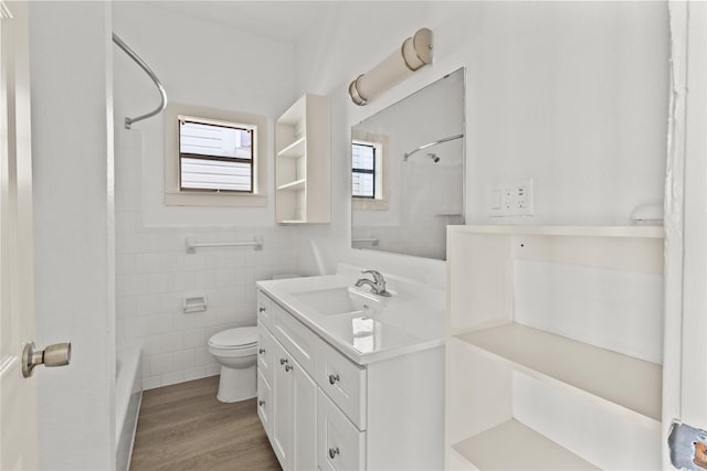 1522 Seawall Blvd, Galveston, TX 77550 - full bathroom with vanity, tile walls, wood finished floors, and shower / bath combination