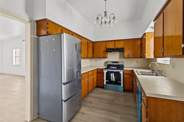 1522 Seawall Blvd, Galveston, TX 77550 - kitchen featuring stainless steel appliances, under cabinet range hood, brown cabinets, a chandelier, and light wood-style flooring