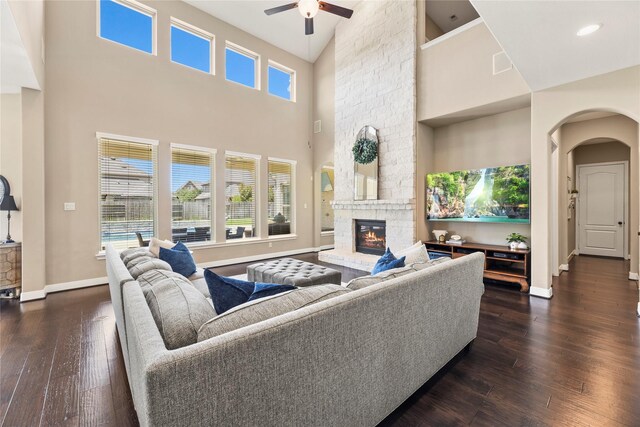 27710 Bering Crossing Dr, Katy, TX 77494 - living room featuring high vaulted ceiling, ceiling fan, baseboards, a fireplace, and dark wood-style flooring