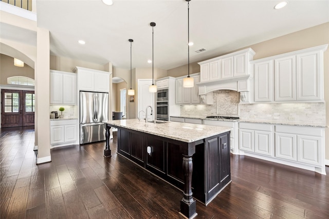 27710 Bering Crossing Dr, Katy, TX 77494 - kitchen with stainless steel appliances, arched walkways, decorative backsplash, dark wood-style floors, and pendant lighting