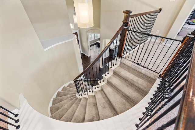 27710 Bering Crossing Dr, Katy, TX 77494 - staircase featuring a towering ceiling, wood finished floors, and baseboards