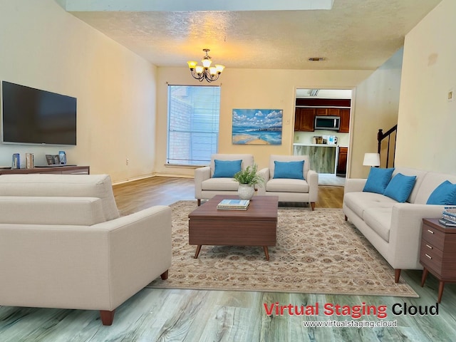 11703 Glenwolde Dr, Houston, TX 77099 - living area with a chandelier, wood finished floors, a textured ceiling, stairs, and baseboards