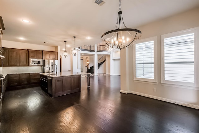 3322 Mallard Run Ct, Katy, TX 77494 - kitchen featuring appliances with stainless steel finishes, dark wood-type flooring, a chandelier, a kitchen island with sink, and decorative light fixtures