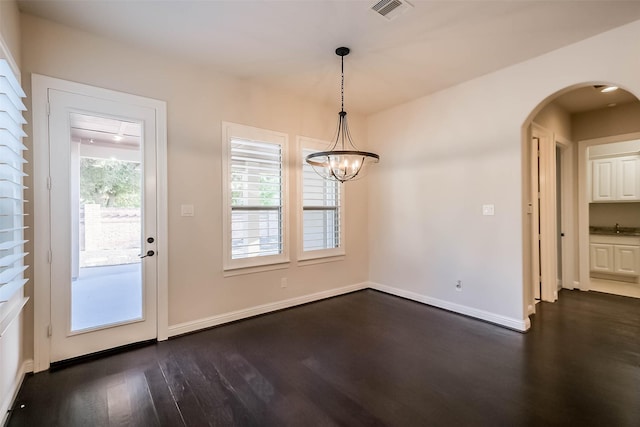 3322 Mallard Run Ct, Katy, TX 77494 - unfurnished dining area featuring dark wood finished floors, arched walkways, a sink, baseboards, and a chandelier