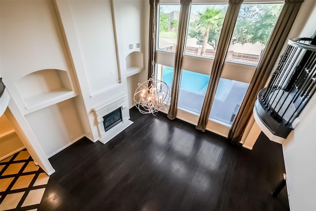 3322 Mallard Run Ct, Katy, TX 77494 - living room featuring a fireplace, built in features, dark wood-style flooring, and a chandelier