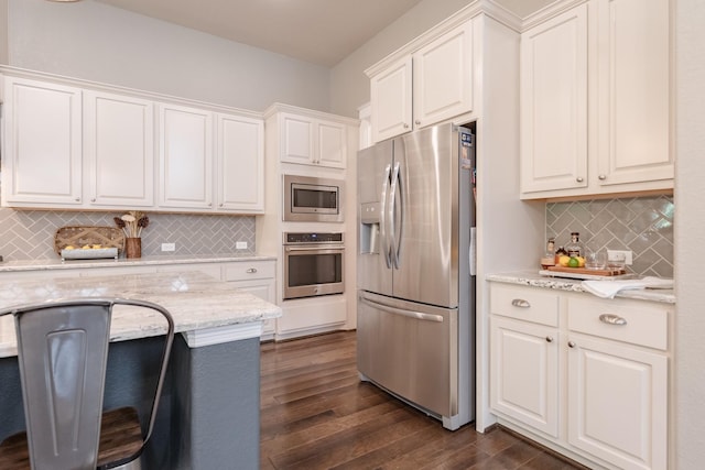 151 Jacks Corner Dr, Montgomery, TX 77316 - kitchen featuring appliances with stainless steel finishes, dark wood-style flooring, tasteful backsplash, light stone counters, and white cabinetry