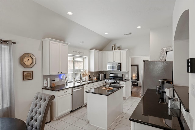 2506 Abernathy Glen Ct, Houston, TX 77014 - kitchen with stainless steel appliances, a sink, dark countertops, a center island, and backsplash