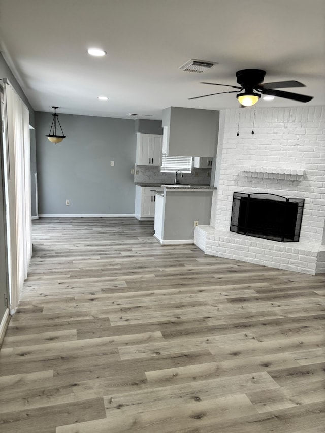 815 Pebbleshire Dr, Houston, TX 77062 - unfurnished living room featuring ceiling fan, light wood finished floors, baseboards, a sink, and recessed lighting