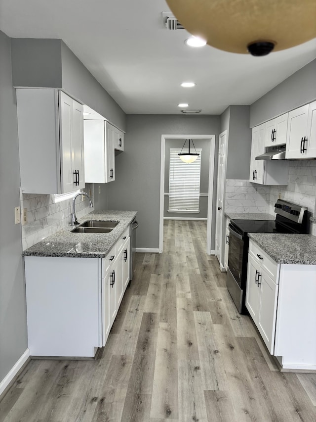 815 Pebbleshire Dr, Houston, TX 77062 - kitchen featuring a sink, stainless steel appliances, under cabinet range hood, dark stone countertops, and baseboards