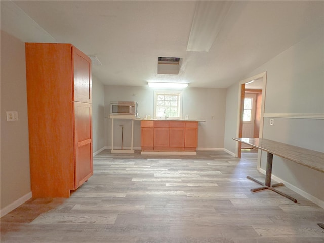 403 Fern Ln, Wharton, TX 77488 - kitchen featuring stainless steel microwave, healthy amount of natural light, and light wood-type flooring