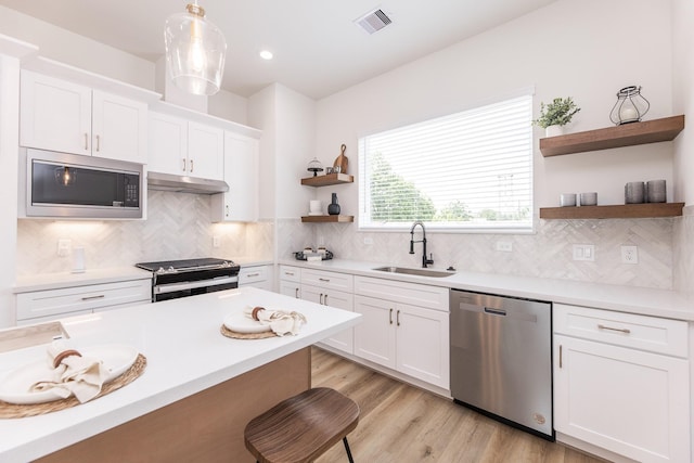 1613 Erin St, Houston, TX 77009 - kitchen with stainless steel appliances, a sink, open shelves, white cabinetry, and light countertops