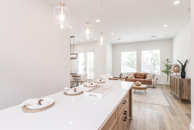 1613 Erin St, Houston, TX 77009 - kitchen with light wood-type flooring, healthy amount of natural light, light countertops, recessed lighting, and hanging light fixtures