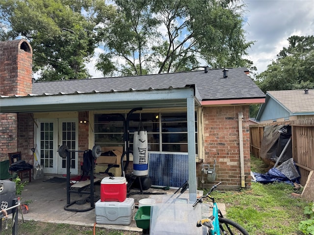5319 Straight Arrow Dr, Humble, TX 77346 - back of property featuring french doors, roof with shingles, brick siding, and a chimney