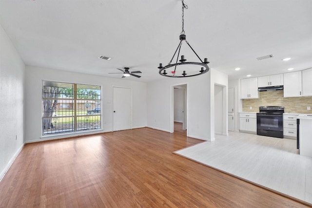 2635 Dragonwick Dr, Houston, TX 77045 - unfurnished living room featuring baseboards, light wood-type flooring, ceiling fan, and a chandelier