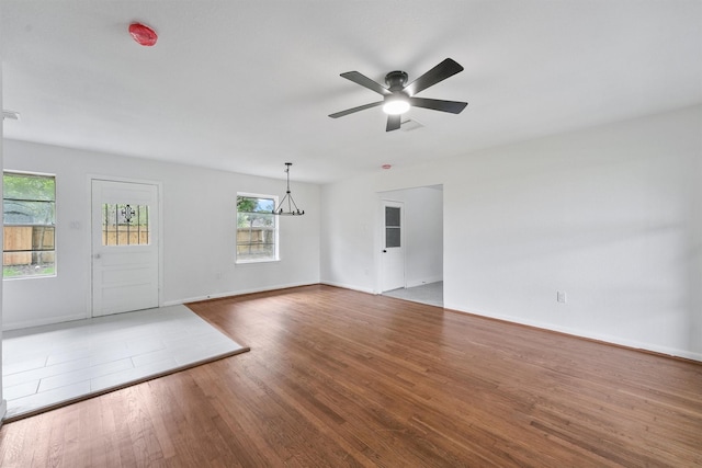 2635 Dragonwick Dr, Houston, TX 77045 - unfurnished living room with a ceiling fan, wood finished floors, baseboards, and a chandelier