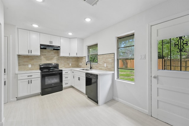 2635 Dragonwick Dr, Houston, TX 77045 - kitchen with black appliances, a sink, under cabinet range hood, light countertops, and white cabinets