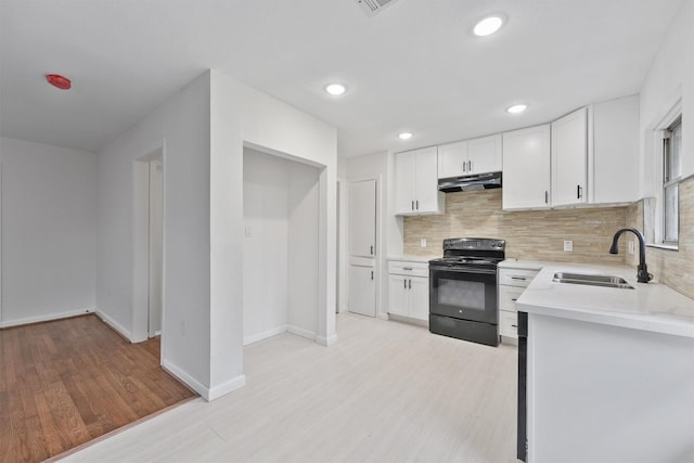 2635 Dragonwick Dr, Houston, TX 77045 - kitchen with a sink, black electric range, under cabinet range hood, decorative backsplash, and light countertops