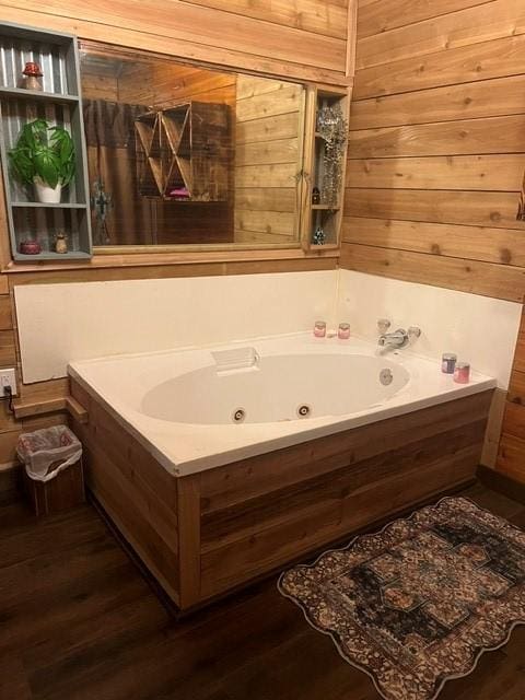 327 3rd St, Dickinson, TX 77539 - bathroom featuring a tub with jets, wood walls, and wood finished floors