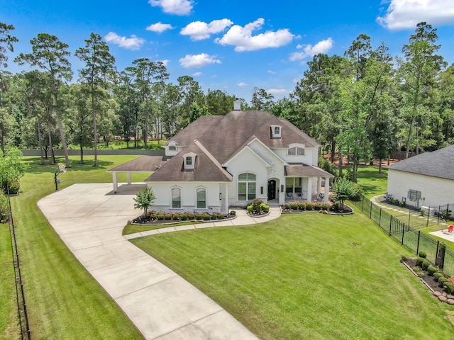 28310 Whispering Maple Way, Spring, TX 77386 - french country inspired facade with stucco siding, a chimney, a porch, concrete driveway, and view of wooded area