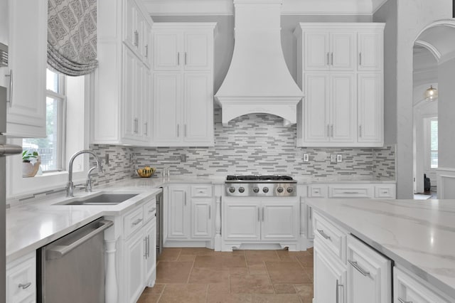 28310 Whispering Maple Way, Spring, TX 77386 - kitchen featuring stainless steel appliances, premium range hood, white cabinets, a sink, and ornamental molding