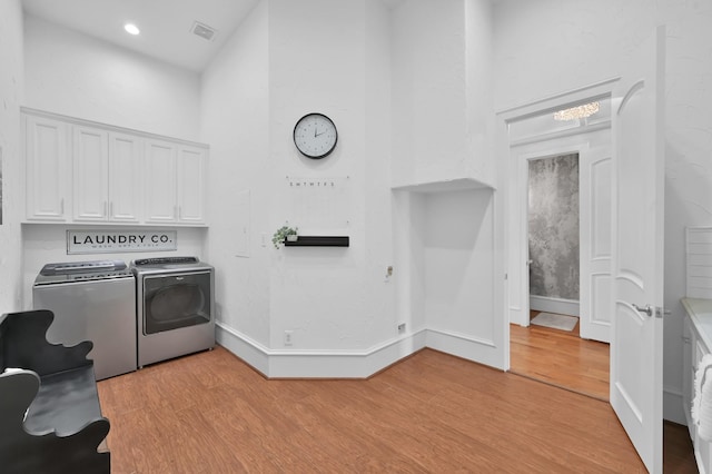 28310 Whispering Maple Way, Spring, TX 77386 - laundry room with independent washer and dryer, a towering ceiling, cabinet space, light wood-type flooring, and baseboards