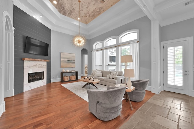 28310 Whispering Maple Way, Spring, TX 77386 - living area featuring healthy amount of natural light, a tray ceiling, arched walkways, a fireplace, and a towering ceiling